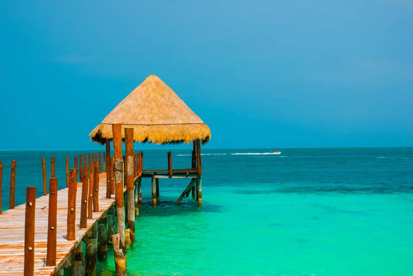 Pier en de houten prieel aan het strand. Tropische landschap met steiger: zee, zand, stenen, golven, turkoois water. Mexico, Cancún — Stockfoto