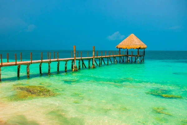 İskele ve plajda ahşap çardak. İskelesi ile tropikal manzara: Deniz, kum, kaya, dalgalar, turkuaz su. Meksika, Cancun — Stok fotoğraf