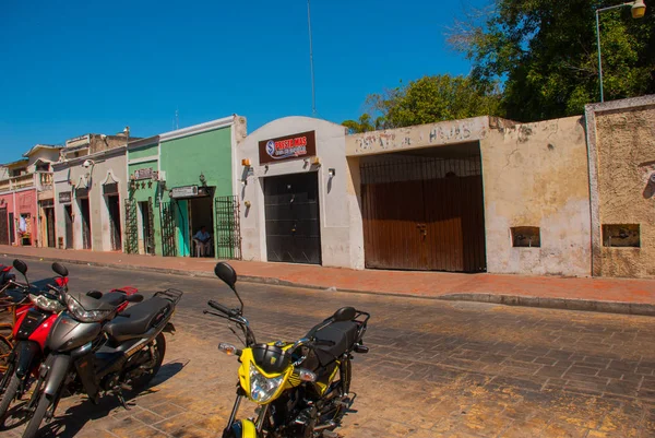 Színes épületek mexikói utcában. A központ a Valladolid Yucatan Mexikó. A az út szélén parkoló motorkerékpárok — Stock Fotó