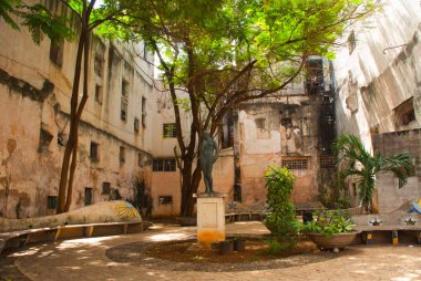 Kare evlerin arasında. Kadın heykel ve mozaik duvar. Havana. Küba