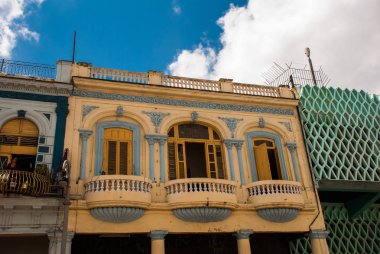 Geleneksel yapılar ile bulutlar mavi gökyüzü arka plan üzerinde renkli cephe ile klasik tarzda. Havana. Küba