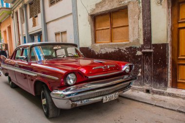 Eski model retro araba kırmızı eski Havana bölgesinde geleneksel bir sokakta. Küba