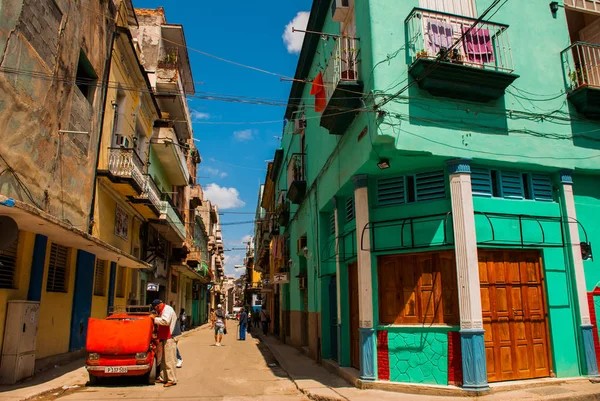 Coche rojo roto. Escena callejera con coches antiguos clásicos y edificios coloridos tradicionales en el centro de La Habana. Cuba — Foto de Stock
