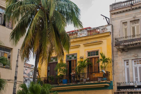 Antiguo edificio amarillo, mujer de pie en el balcón. La Habana. Cuba —  Fotos de Stock