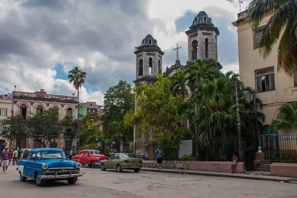 Catedral Católica no fundo do céu com nuvens e carros americanos retro. Havana. Cuba — Fotografia de Stock