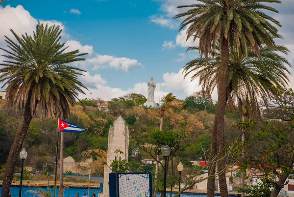 Bandera de Cuba y estatua de Jesucristo en una colina con vista al puerto y a la bahía de La Habana . — Foto de Stock