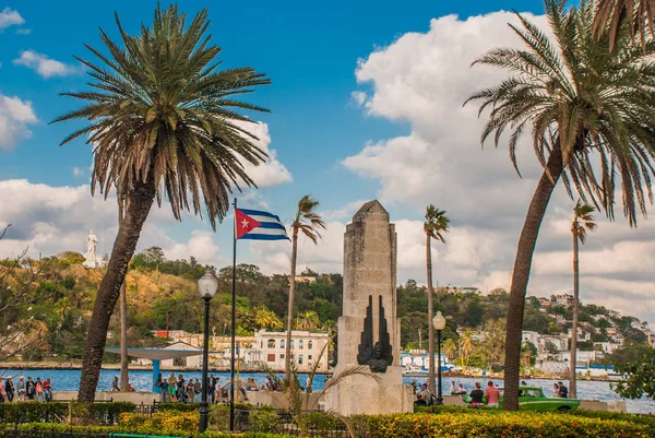 Cuba flag and statue of Jesus Christ on a hill overlooking the port and the bay of Havana.