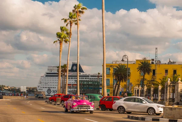 Vista de Malecon beira-mar. Enorme navio no porto de Havana. Carro rosa retro passeios na estrada. Cuba . — Fotografia de Stock