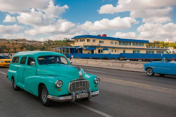 Pohled z nábřeží Malecón. Retro tyrkysové auto jezdí na silnici. Kuba. — Stock fotografie