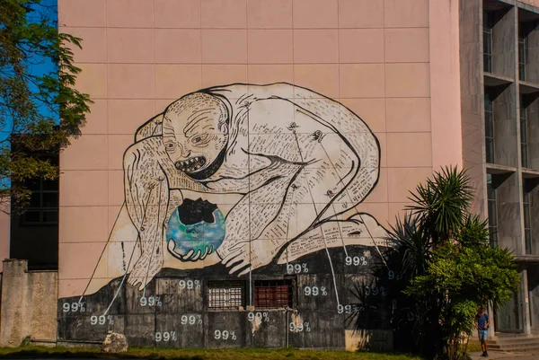 Neobvyklé graffiti na účet podniku, kreslení na zdi: muž nahnul se pokousal zeměkoule v ruce. Havana. Kuba — Stock fotografie