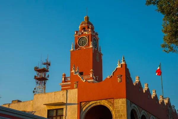 stock image Red brick building tower with golden dome and clock in the City center of Merida. Mexican flag flutters on air. City Town hall of Yucatan in Mexico