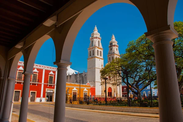 Pohled na hlavní Park přes oblouk budovy knihovny v Campeche, Mexiko. Na pozadí je katedrála del La představa immaculada. — Stock fotografie