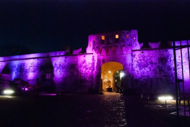 San Francisco de Campeche, Meksika: eski kale duvarı ve tarihi merkeze giriş. Kara kapısı Puerta de Tierra renkli aydınlatma ile gece.