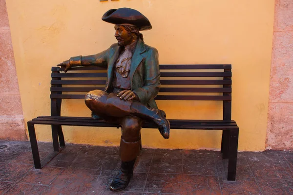 Campeche, Mexiko: Brons staty framför Casa Don Gustavo Hotel, San Francisco de Campeche, mannen i en gammal kostym och hatt sitter på en bänk. — Stockfoto