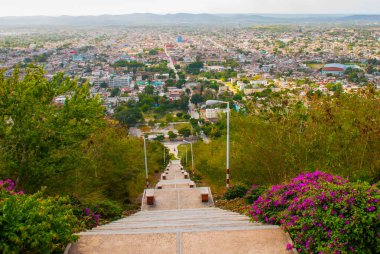 Küba. Holguin: Cross Tepesi 'nden Holguin şehri manzaralı peyzaj. Basamakları aşağı doğru giden bir merdiven. Şehir panoraması.