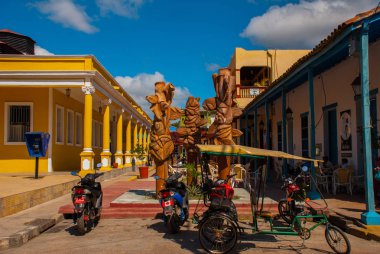 Holguin, Cuba: Motorcycles and bicycles are parked at the monument in the city center clipart