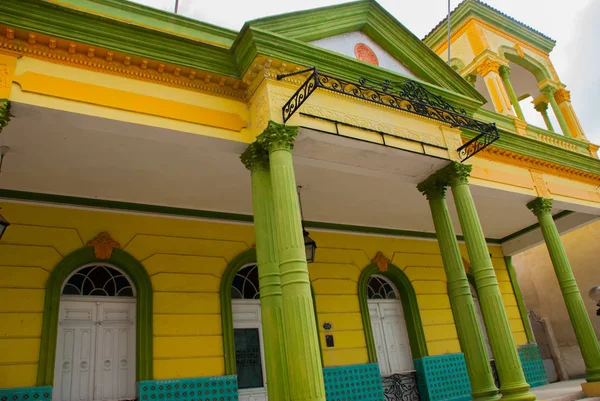 Holguin, Cuba: Classic geel gebouw met groene kolommen in het centrum van de stad. — Stockfoto