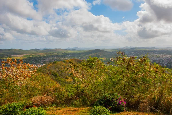 Cuba. Holguín: Vista superior de la ciudad Holguín. Paisaje con árboles, montañas y casas en la distancia . — Foto de Stock