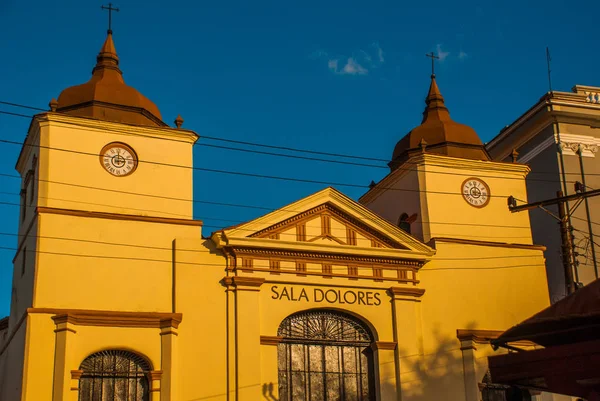 Santiago de Cuba, Kuba: Sala dolortes, żółty budynek z wieżyczki i zegar na ulicy. — Zdjęcie stockowe