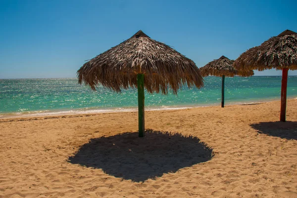 Los paraguas están en la hermosa playa. Cuba. Trinidad. Playa Ancona. Mar Caribe . — Foto de Stock