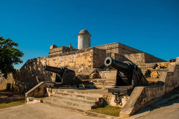 Gamla väderbitna kanoner och skott exposition nära väggarna av Jagua fortet Fortaleza de Jagua. Cienfuegos, Kuba. — Stockfoto