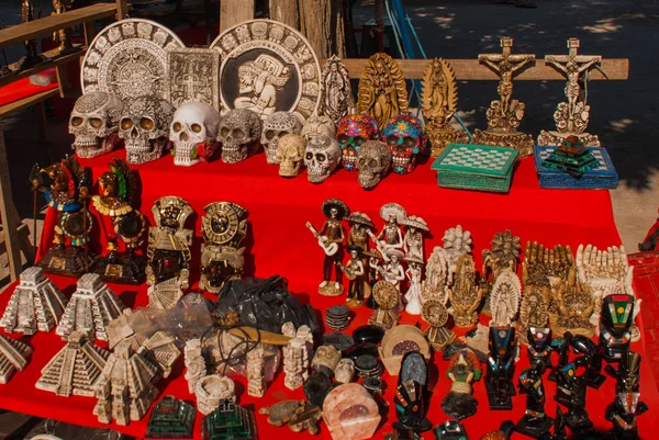 Souvenirs para turistas en México en el mercado. Figuras y estatuas, placas de Maya, calaveras, madre de Dios, Jesucristo, pirámides, esqueleto — Foto de Stock