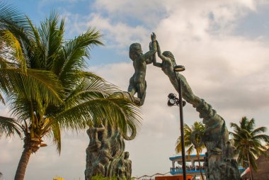 Playa del Carmen, Meksika Beach giriş. Riviera Maya. Bir erkek ve bir kadın ve palmiye ağaçlarının arka planda bir kemer şeklinde heykel