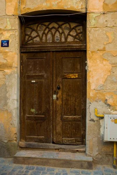 Brasov, Roménia: Porta de madeira antiga. Rua da cidade de Brasov na Romênia. Brasov senta-se na região da Transilvânia da Roménia . — Fotografia de Stock