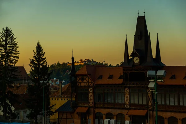 Rumänien, Brasov, Transsylvanien: Vacker gotisk byggnad i gamla stan vid solnedgången. Kvällslandskap med utsikt över staden. — Stockfoto