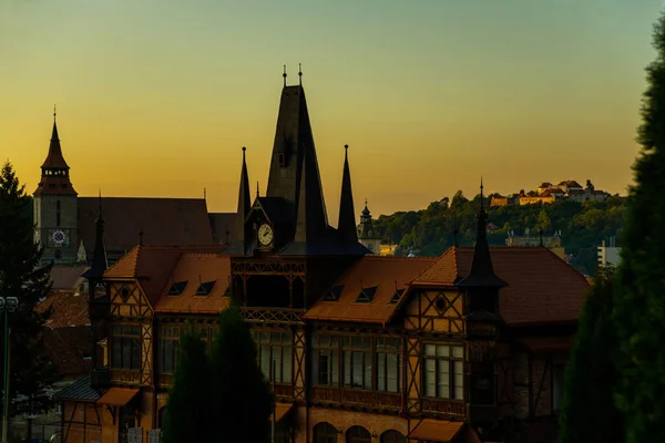 Rumänien, Brasov, Transsylvanien: Vacker gotisk byggnad i gamla stan vid solnedgången. Kvällslandskap med utsikt över staden. — Stockfoto