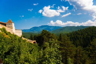 Romanya 'nın tepedeki ortaçağ duvarlı Rasnov kenti. Ortaçağ Kalesi Rasnov ile sonbahar manzarası.