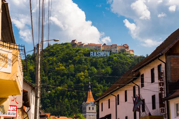 Rasnov, Roemenië: Scenic uitzicht op de centrale straat en Rasnov fort op de top van de heuvel. Plaats: Brasov, Transsylvanië, Roemenië. — Stockfoto