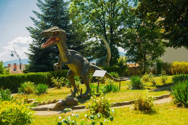 SIBIU, ROUMANIE : Sculpture de dinosaure. Une vue sur un vieux mur de briques et une tour, qui faisaient partie du système de fortification dans la vieille ville de Sibiu — Photo