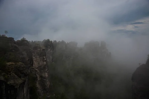 Bastei, Alemanha: Bela paisagem com rochas bastosas no Parque Nacional da Suíça Saxônica. Nevoeiro nas montanhas — Fotografia de Stock