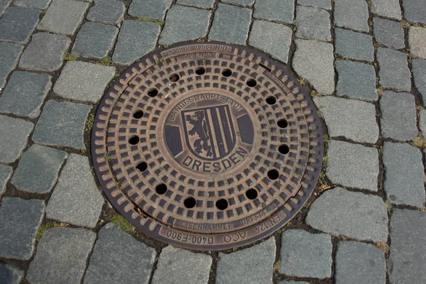 Dresde, Allemagne : Trou d'égout rond en acier sur la chaussée à Dresde — Photo