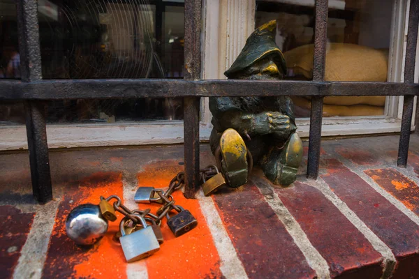 WROCLAW, POLAND: Dwarf on in jail behind bars. Disabled dwarfs statues at Wroclaw Market square near Old Town hall. — Stock Photo, Image