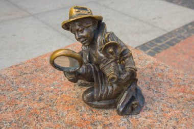 Wroclaw, Polonya: Büyüteçle fotoğrafçı kız merdiven taşıyan cücelere bakıyor.