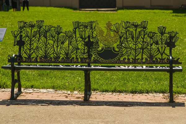 Krakow, Polen: Ovanlig bänk för turister i parken — Stockfoto