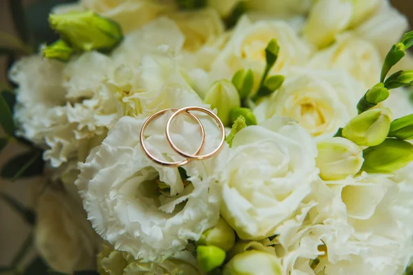 Día de San Valentín. Boda. Hermosos anillos de boda y un ramo de rosas blancas — Foto de Stock