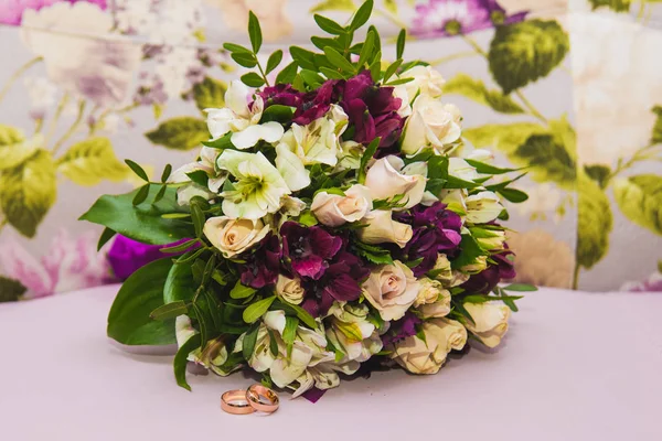 Día de San Valentín. Boda. Hermosos anillos de boda y un ramo de rosas blancas — Foto de Stock