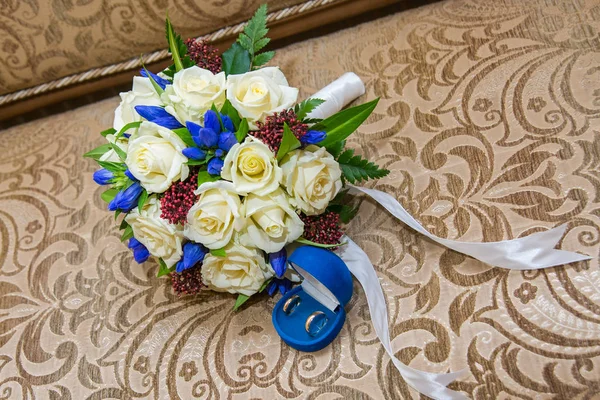 Mooie delicate bruiloft boeket witte rozen en trouwringen van de bruid en bruidegom. — Stockfoto