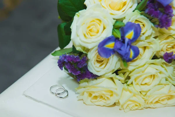 Schöne zarte Brautstrauß weiße Rosen und Trauringe des Brautpaares. — Stockfoto