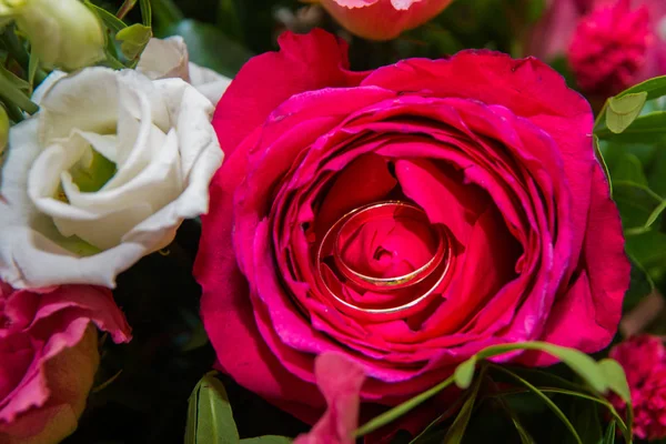 BODAS, Anillos y flores: Anillos de novia y ramo de rosas rojas . —  Fotos de Stock