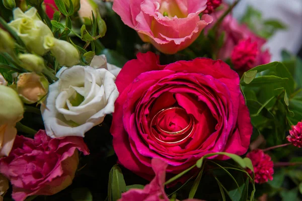 BODAS, Anillos y flores: Anillos de novia y ramo de rosas rojas . —  Fotos de Stock
