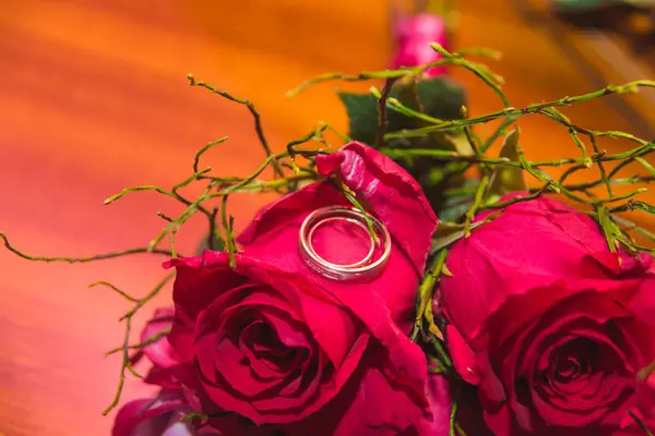 Bröllop, Ringar och blommor: Bröllop ringar och brudbukett av röda rosor. — Stockfoto