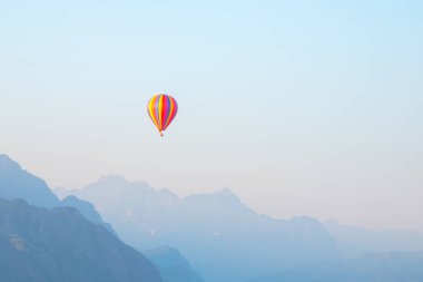 VANG VIENG, LAOS: beautiful landscape with a striped balloon flying over the land and mountains of Laos. Popular entertainment for tourists.