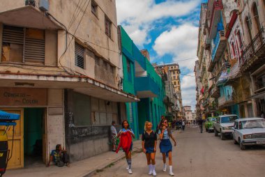 Havana, Küba - Mart 2018: Mahalle sakinleriyle sokak manzarası. Havana şehir merkezinde klasik eski arabaların ve geleneksel renkli binaların olduğu sokak sahnesi.