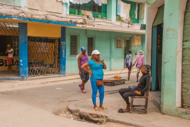Havana, Küba - Mart 2018: Mahalle sakinleriyle sokak manzarası. Havana şehir merkezinde klasik eski arabaların ve geleneksel renkli binaların olduğu sokak sahnesi.