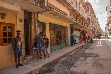 Havana, Küba - Mart 2018: Mahalle sakinleriyle sokak manzarası. Havana şehir merkezinde klasik eski arabaların ve geleneksel renkli binaların olduğu sokak sahnesi.