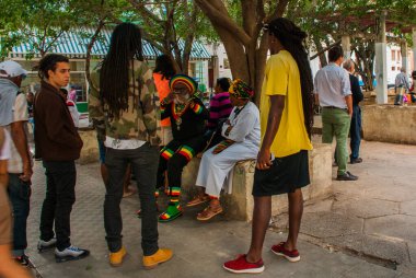 Havana, Küba - Mart 2018: Mahalle sakinleriyle sokak manzarası. Havana şehir merkezinde klasik eski arabaların ve geleneksel renkli binaların olduğu sokak sahnesi.